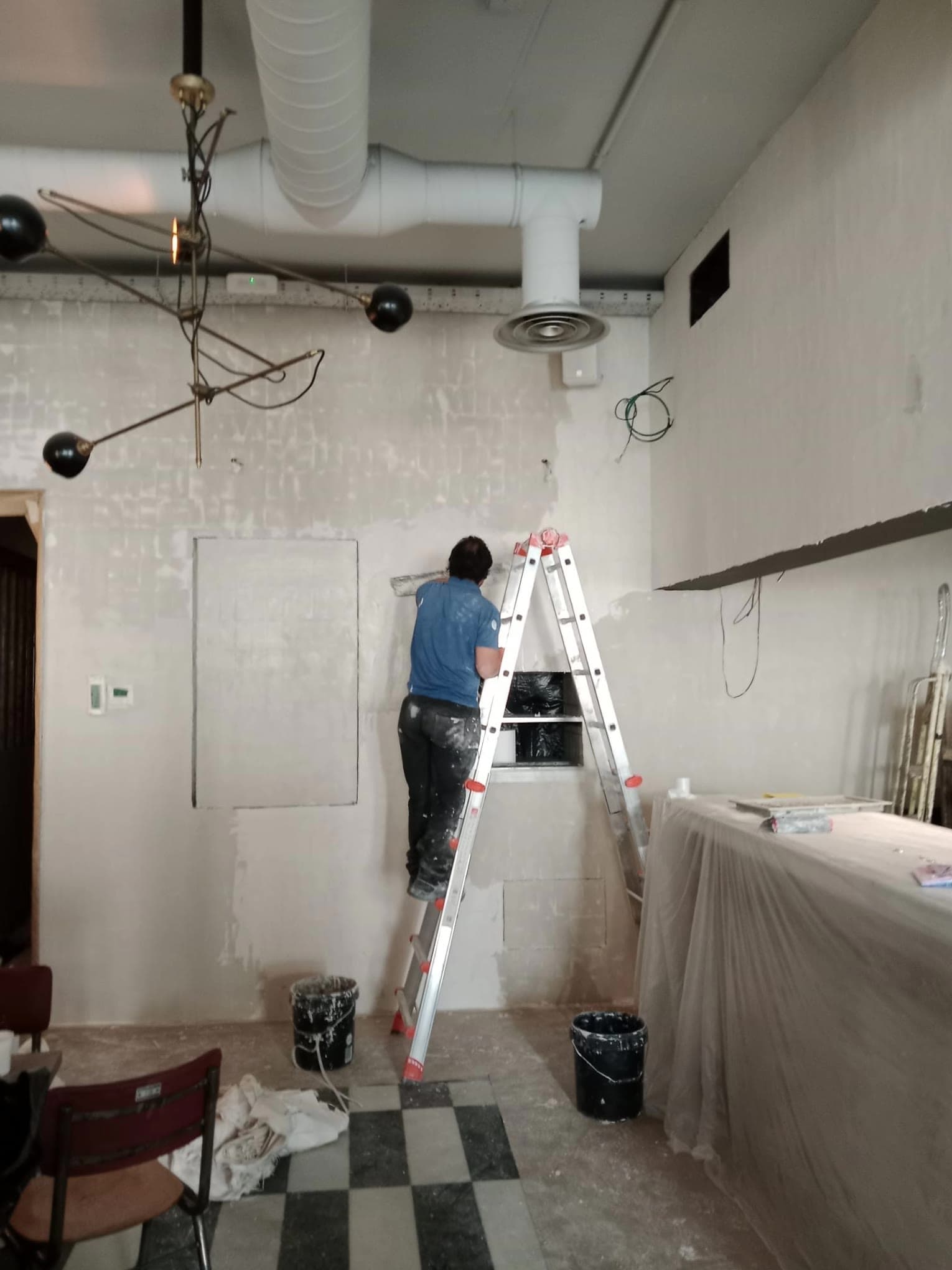 Operario sobre una escalera durante una obra de reforma en curso