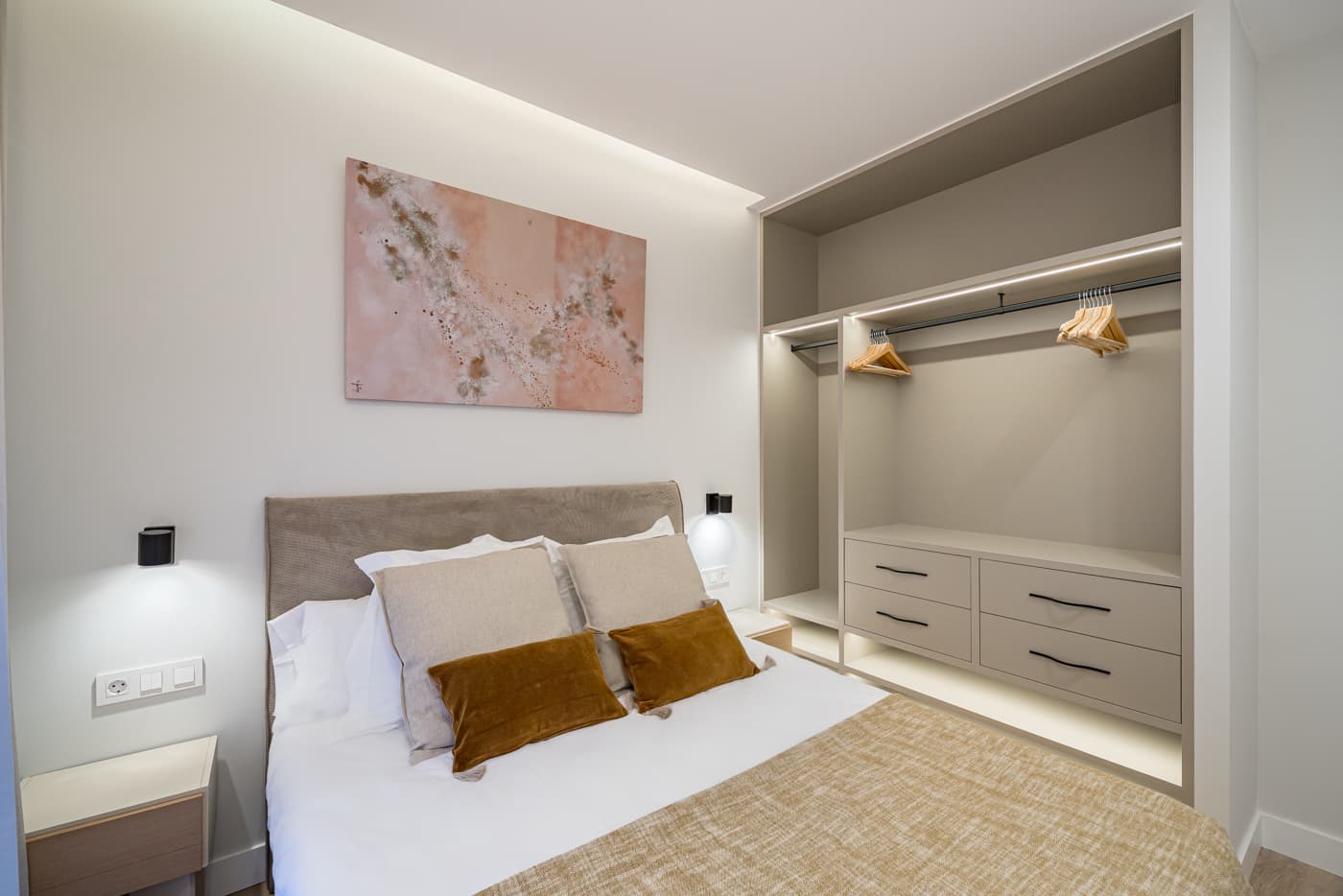 Dormitorio con armario abierto a medida e iluminación integrada. Jesús del Valle 25, Madrid.