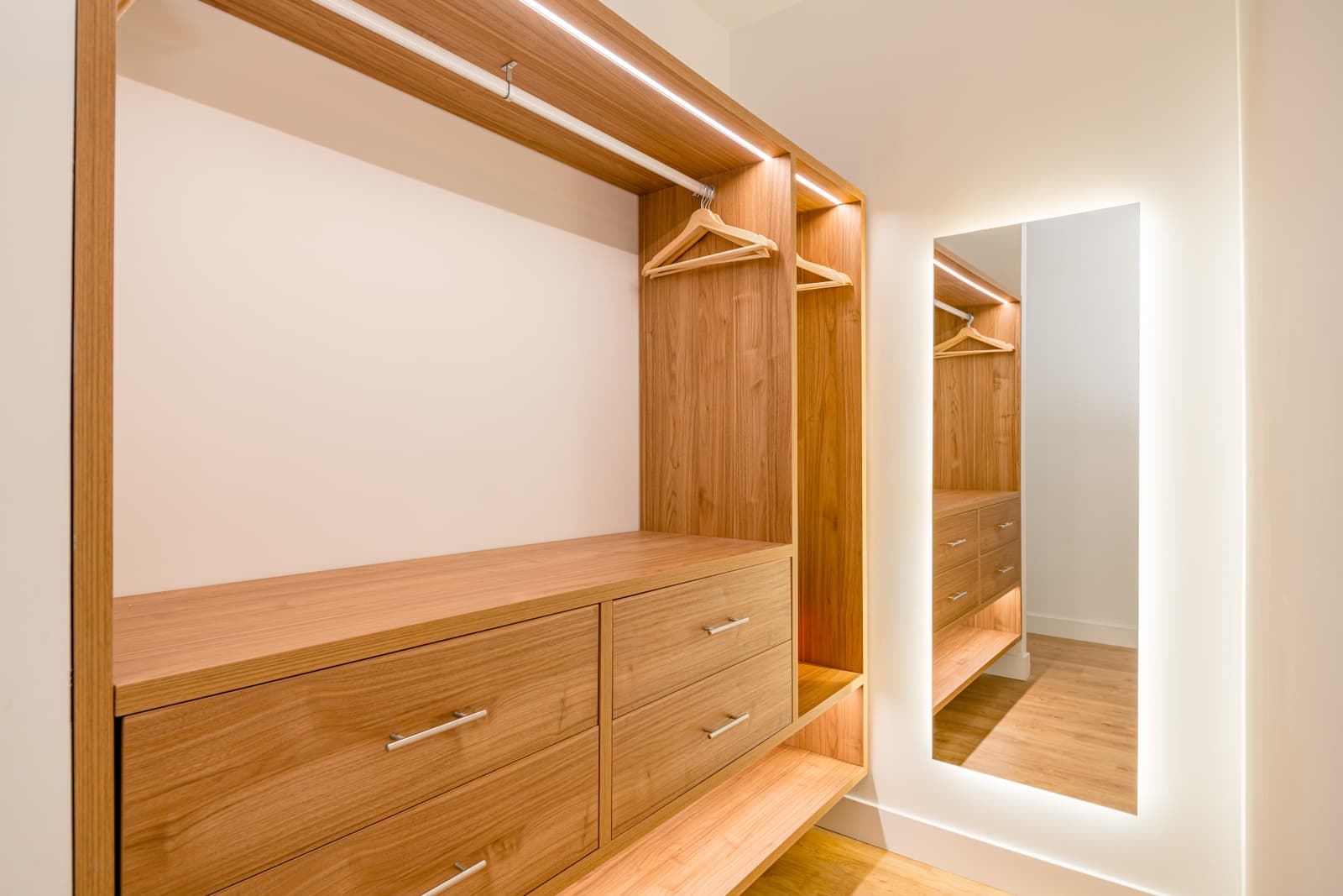 Vestidor abierto en acabado madera, con cajonera, barra y espejo retroiluminado. Lagasca 136, Madrid.