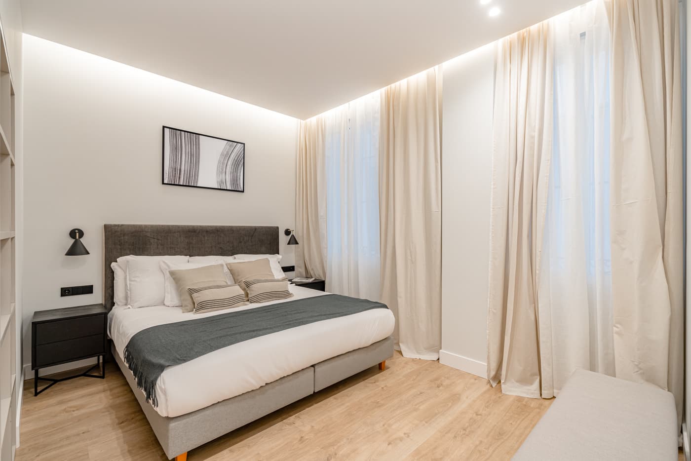Dormitorio con foseado iluminado y cortinas de suelo a techo. Plaza de Santa Bárbara 6, Madrid.